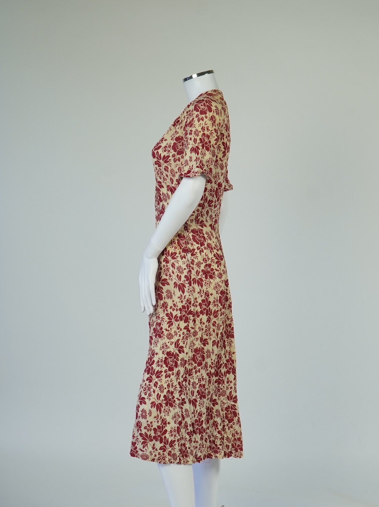 Two 1930's printed silk crepe summer day dresses together with a similar pale blue and black stripped summer day dress., Condition - the maroon and cream dress has damage to one sleeve, the green dress has worn under the